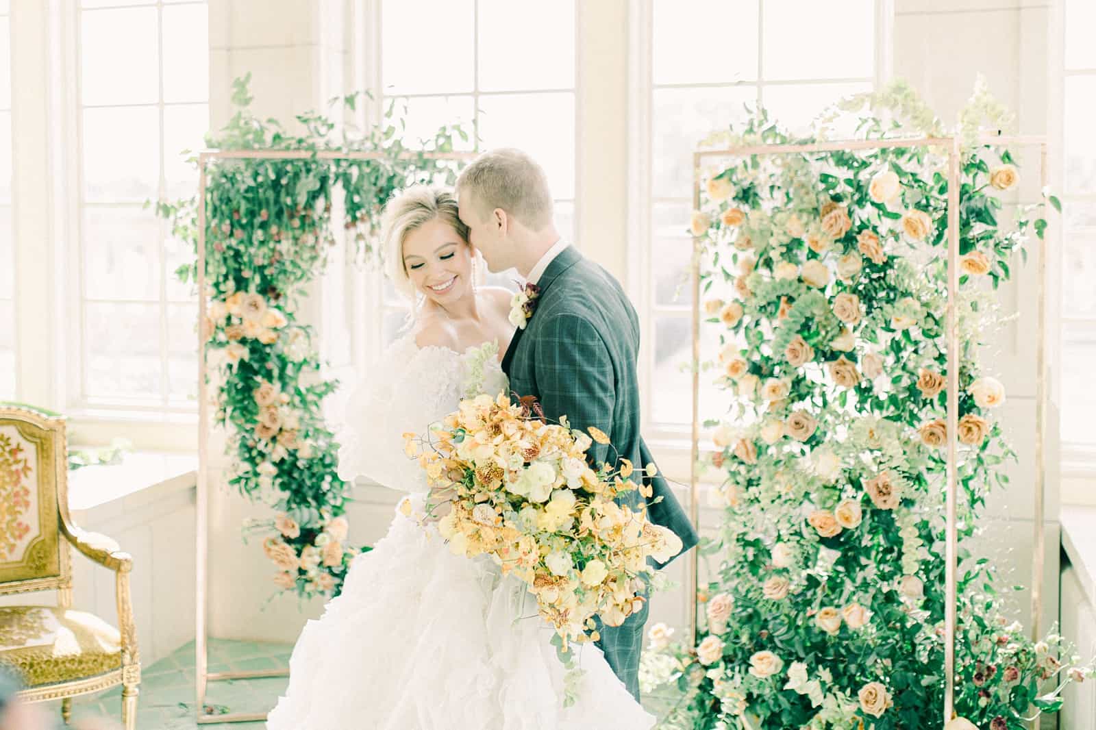 Bride and groom wedding ceremony with elaborate floral backdrop