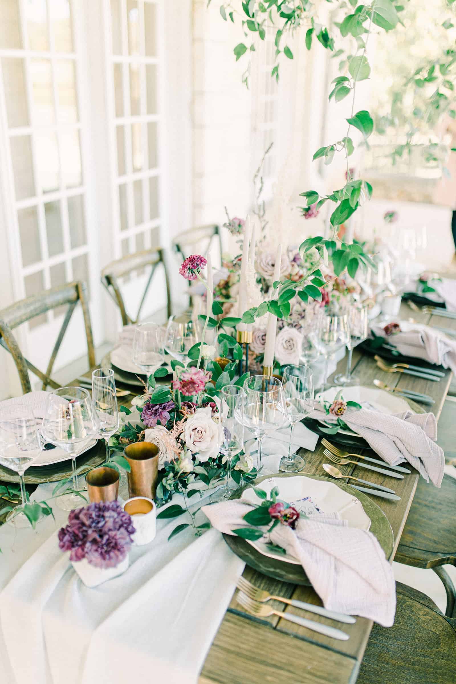 Garden wedding decor, gold goblets and candlesticks, greenery canopy