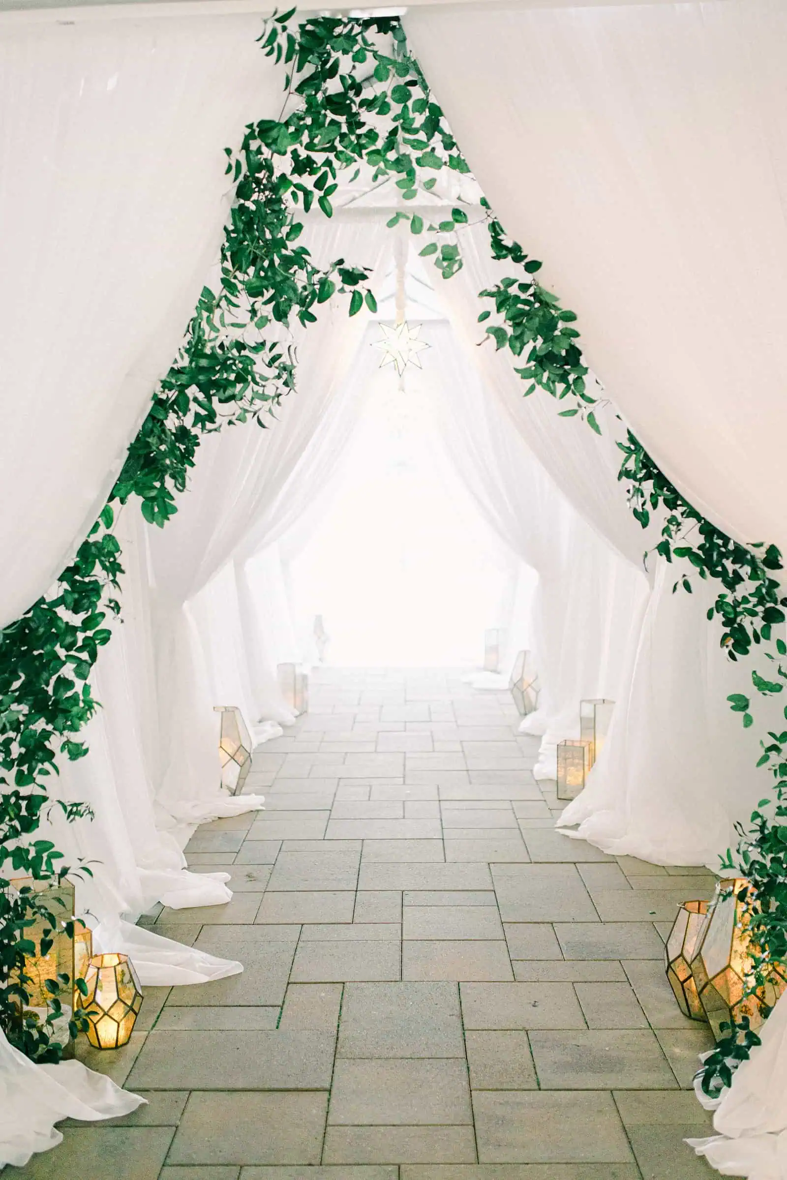 Luxury winter wedding at Willowbridge Estate in Boise, Idaho, white tent reception entrance with greenery and candles lanterns