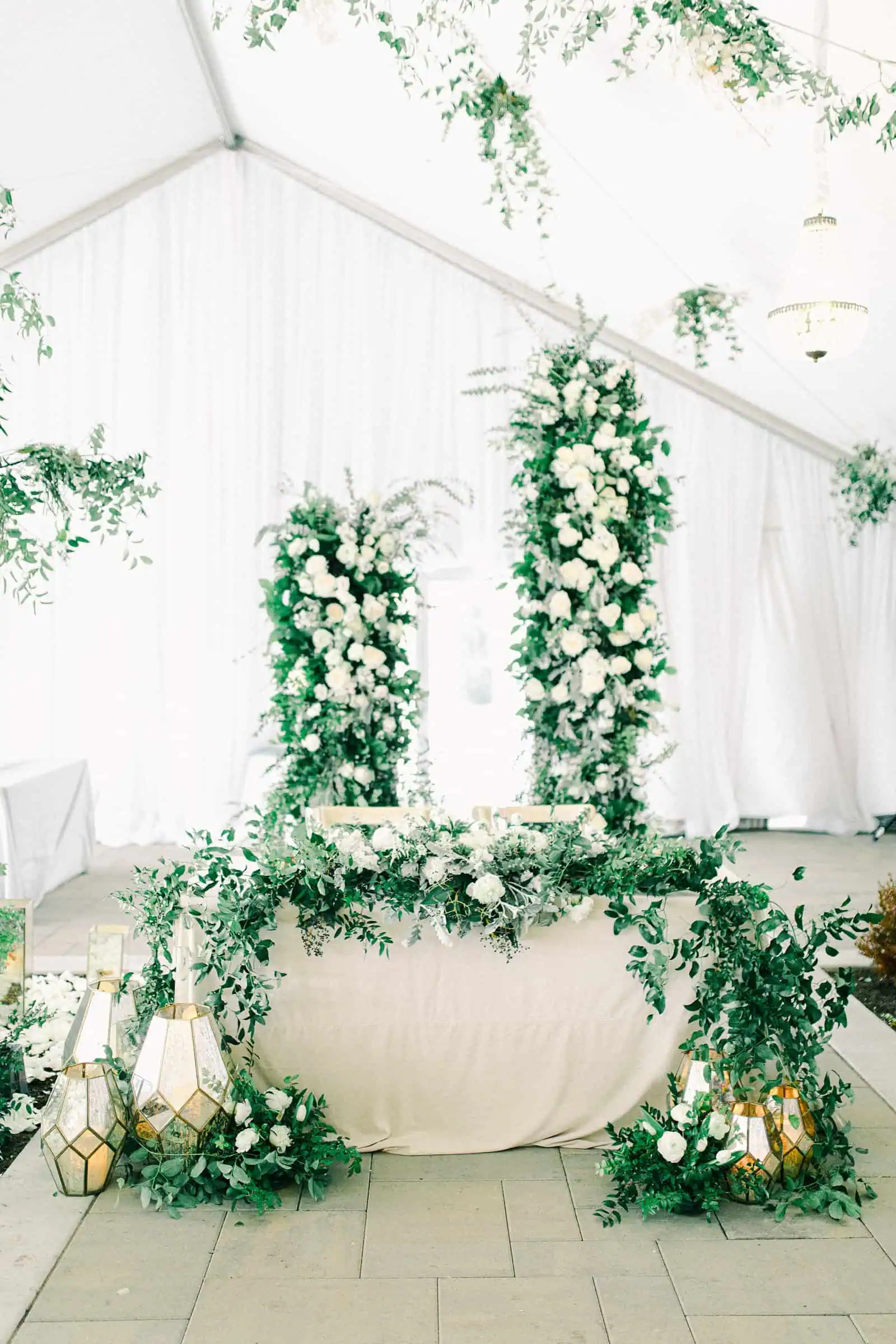 Luxury winter wedding at Willowbridge Estate in Boise, Idaho, floral arch with white flowers roses and greenery backdrop