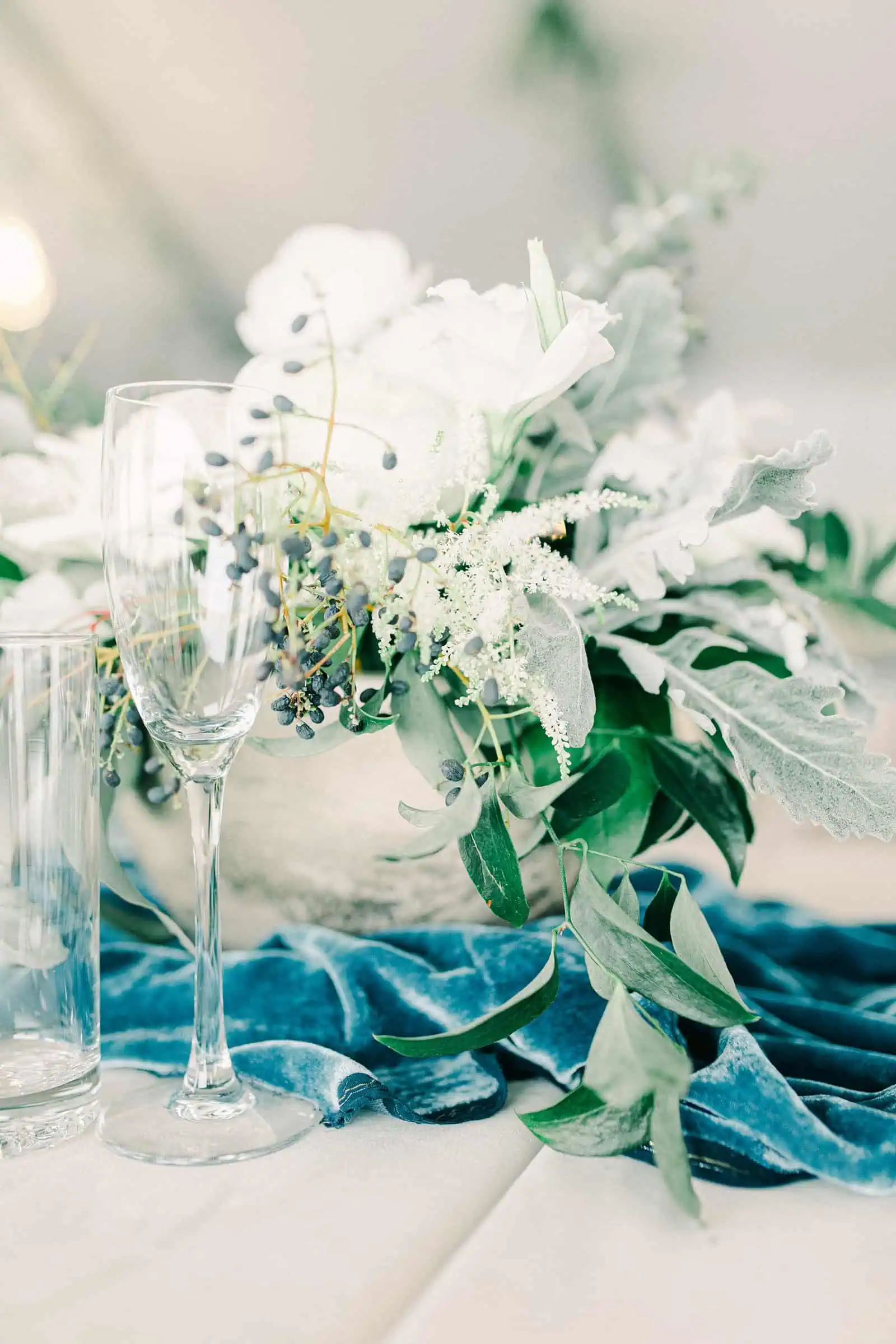 Winter wedding at Willowbridge Estate in Boise, Idaho, all white rose centerpieces with blue velvet runner