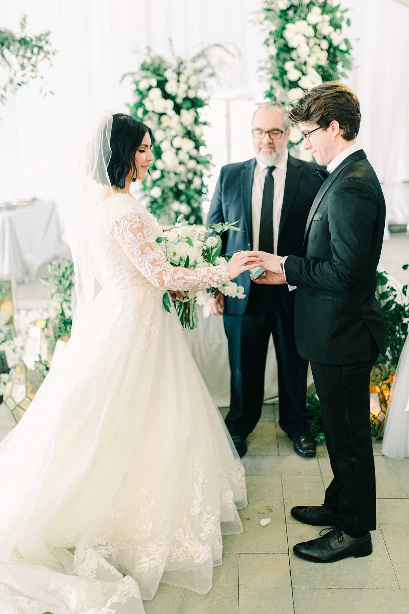 Wedding ceremony in white tent, ring exchange