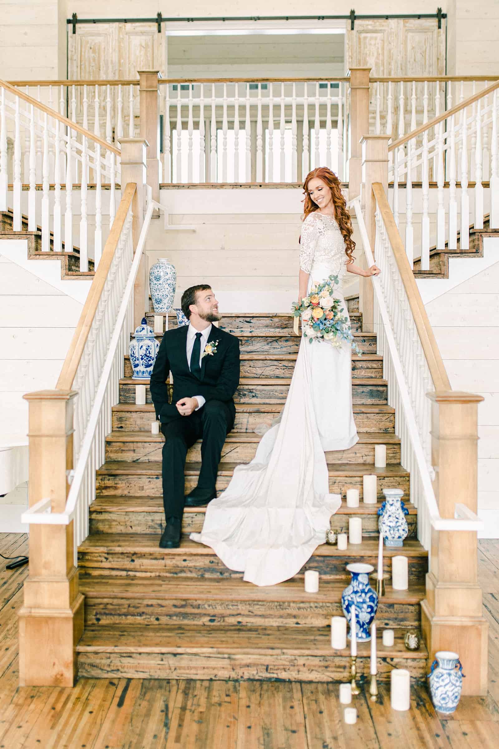 Bride and groom on staircase with vases and candles