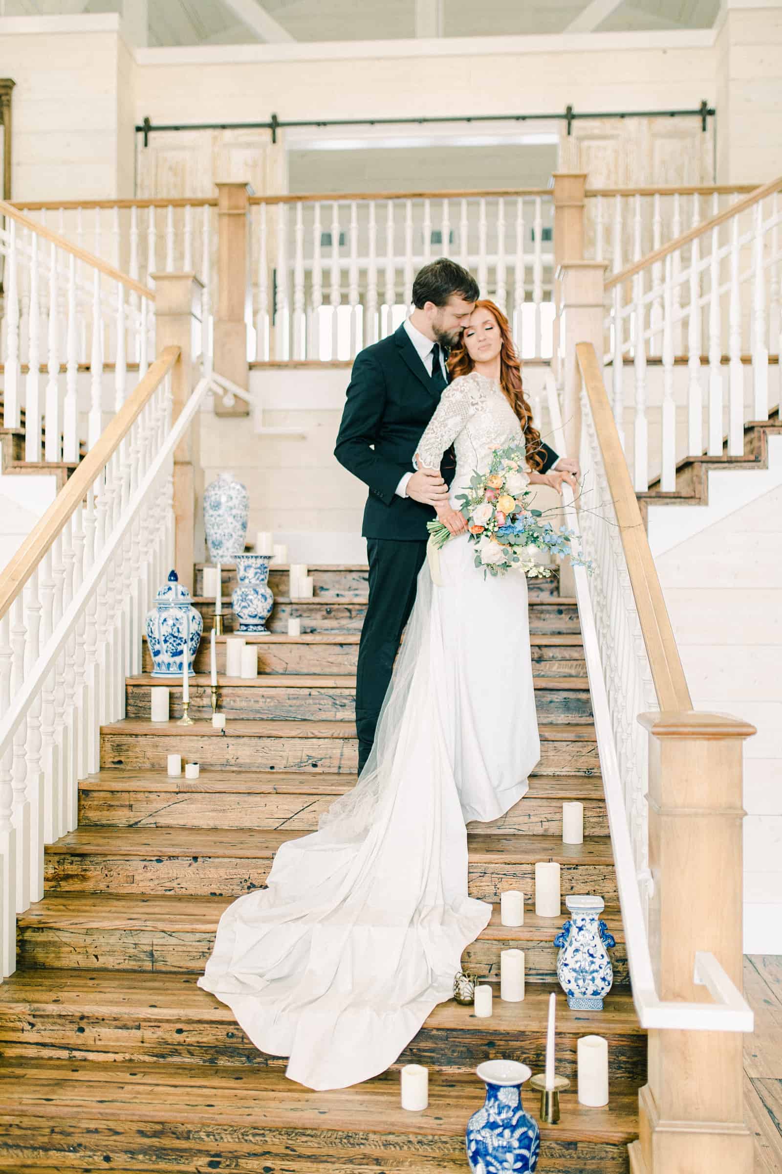 Bride and groom on staircase with vases and candles, Utah County wedding venue