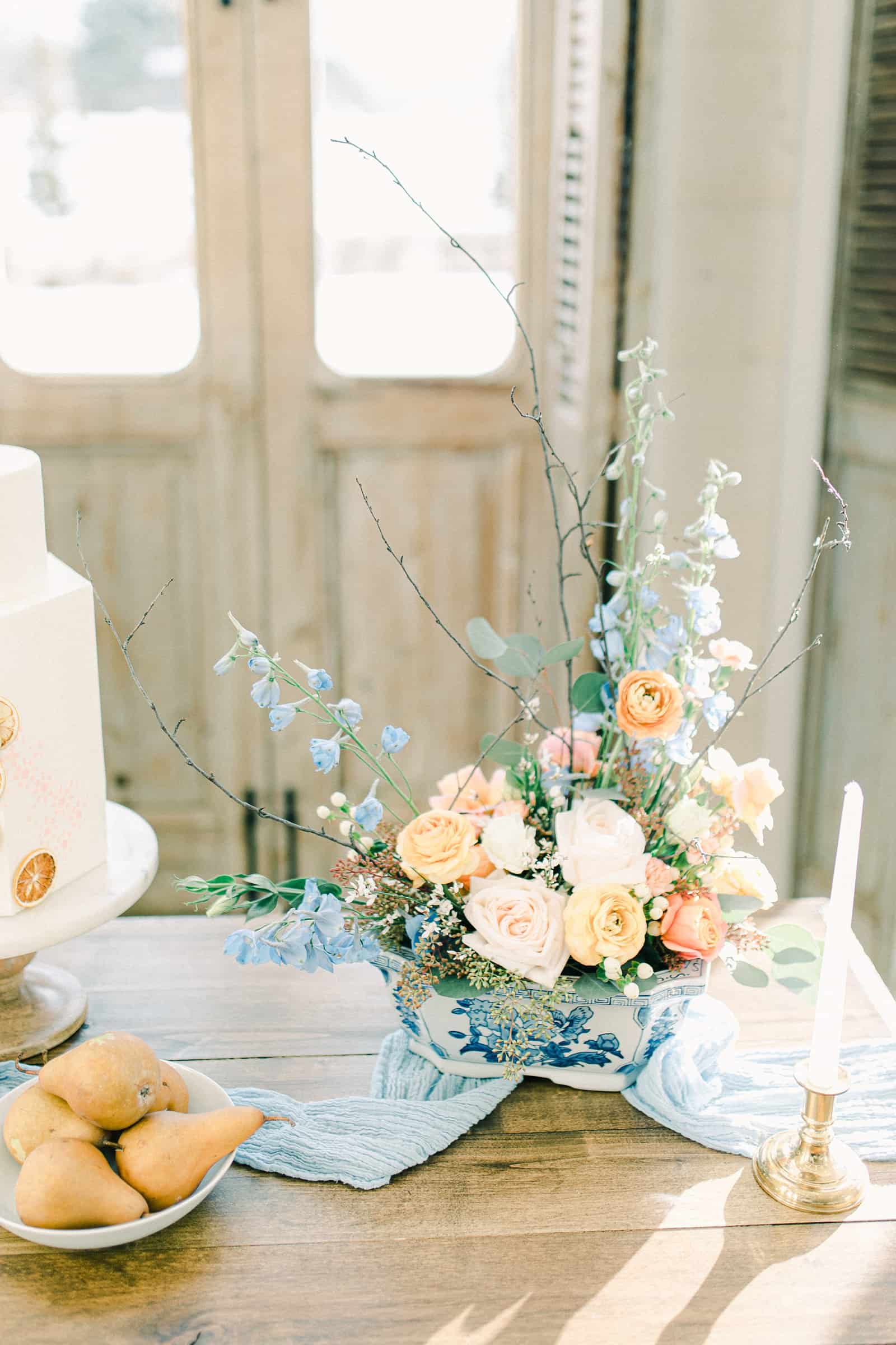 Wedding flowers, florist centerpiece, pastel wedding colors, light blue table runner, white buttercream wedding cake