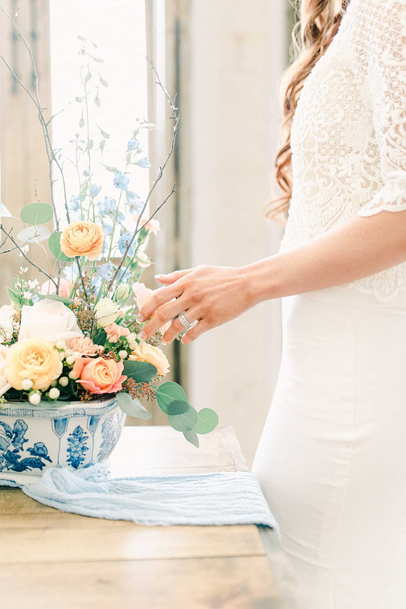 Bride with red hair wearing three quarter length sleeve lace wedding dress and veil, pastel wedding colors, spring wedding centerpiece