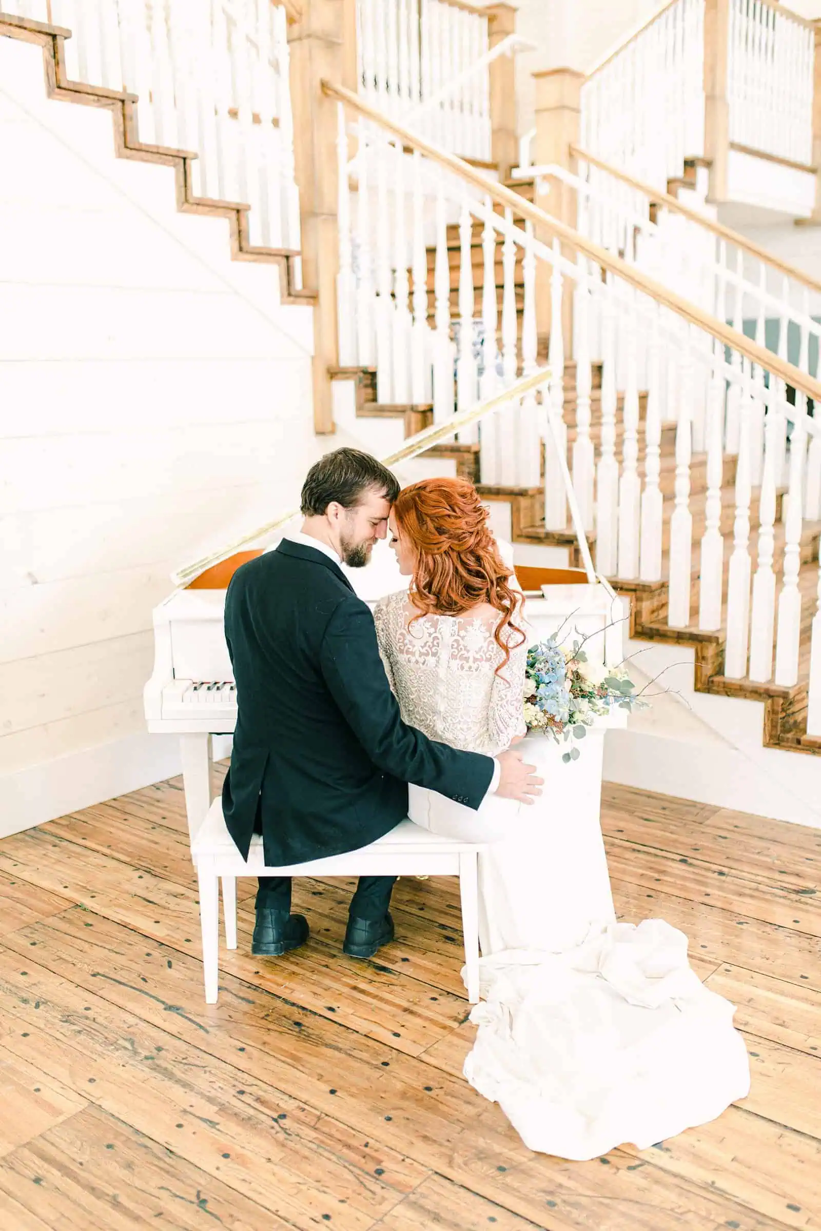 Bride and groom sit at white baby grand piano, Walker Farms wedding, Utah wedding venue, white barn wedding venue, Utah wedding photography