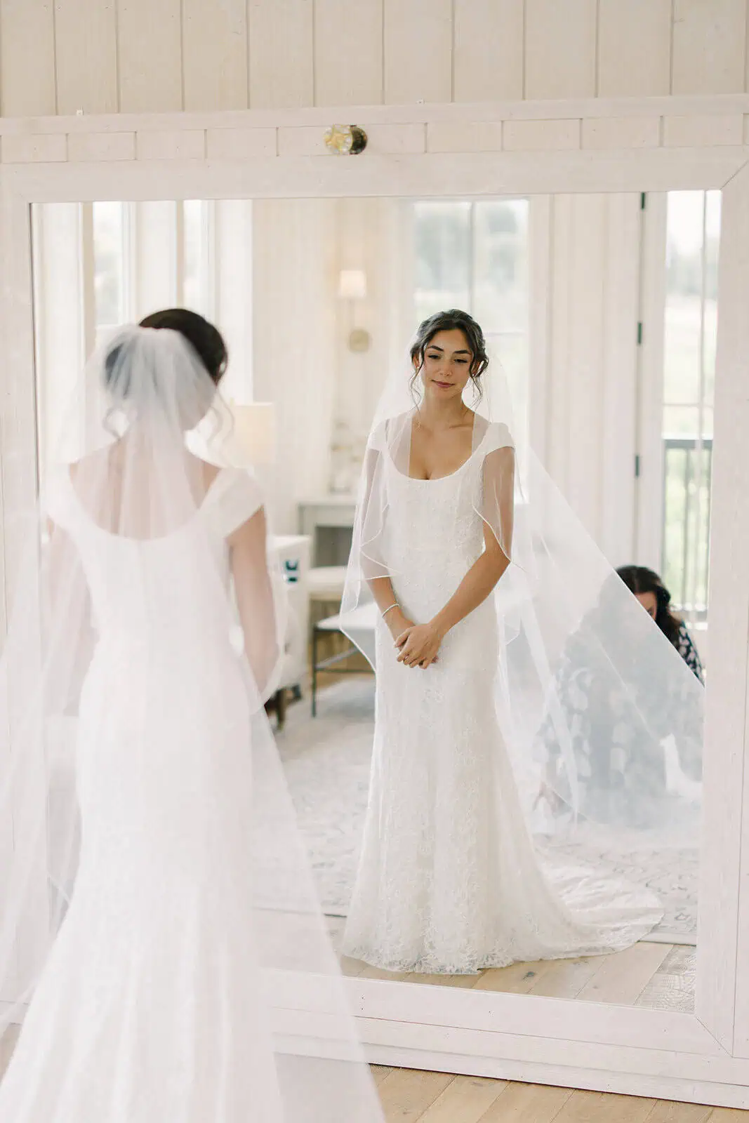 Bride trying on wedding dress in mirror at Branson Maxwell.