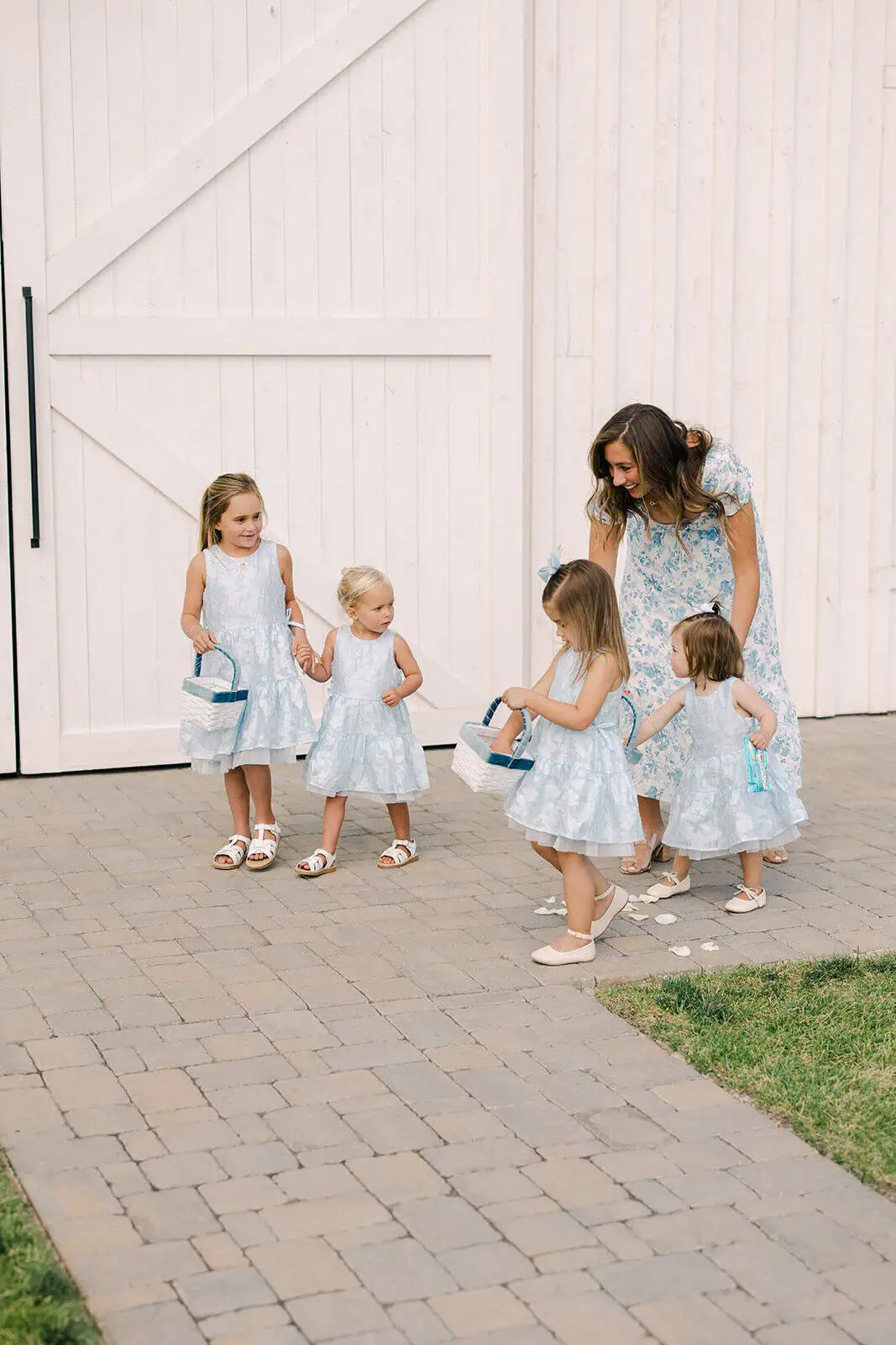 Women and children in matching blue dresses at outdoor event.