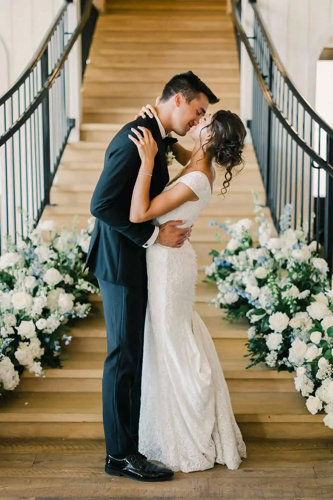 Elegant bride and groom sharing a romantic moment on a staircase.