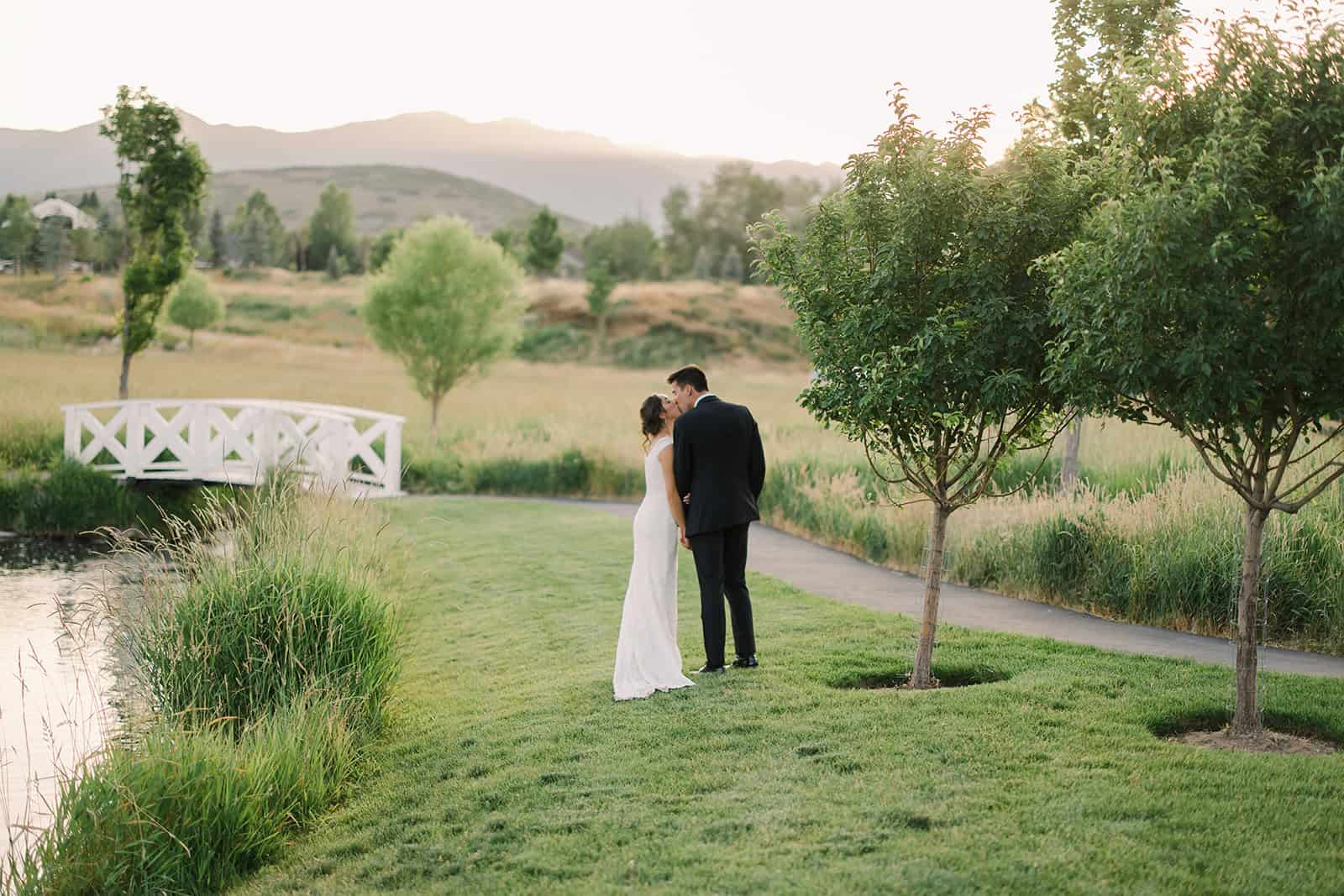 Elegant couple sharing a moment by the water at sunset.