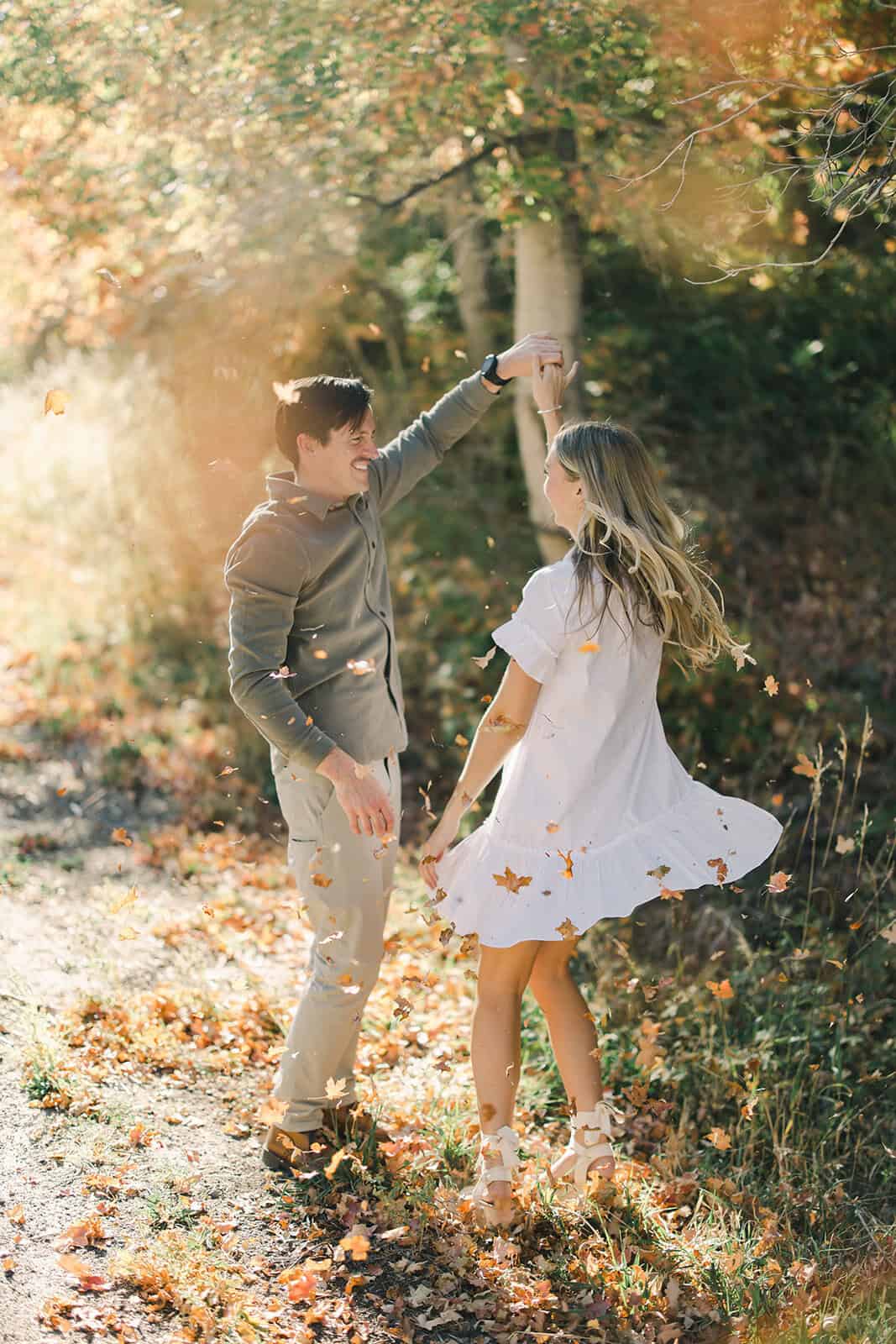 Children dancing in autumn forest, enjoying a sunny day.