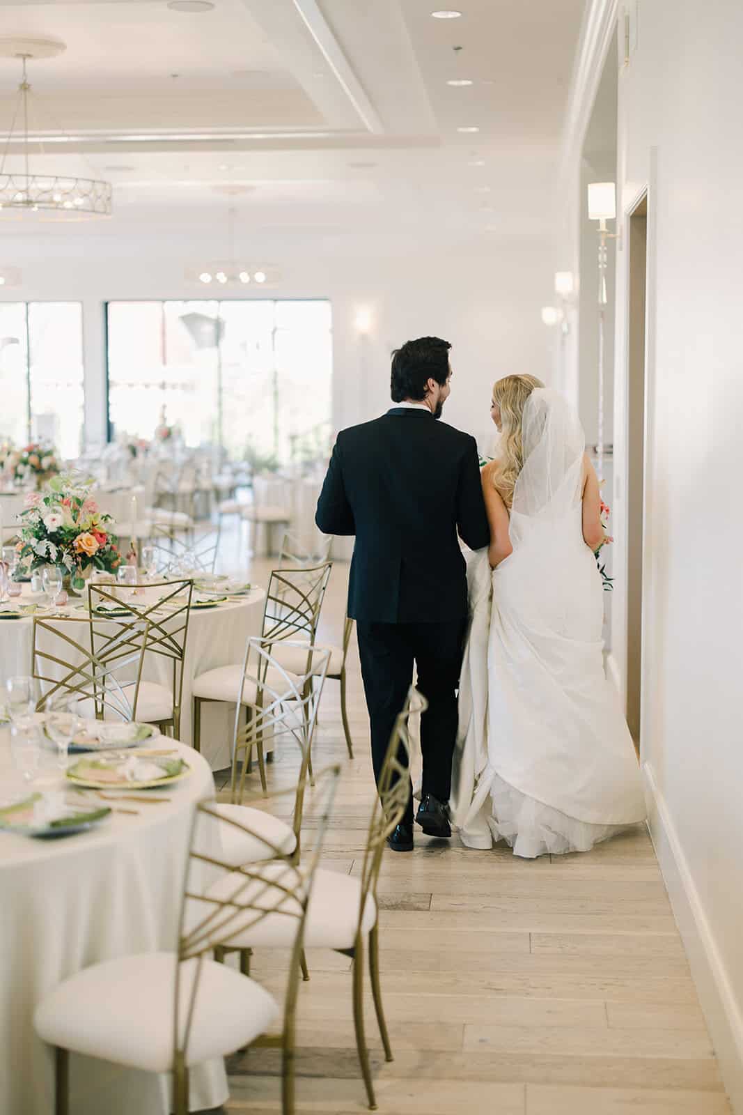 Elegant wedding reception hall with beautifully set tables and floral centerpieces.