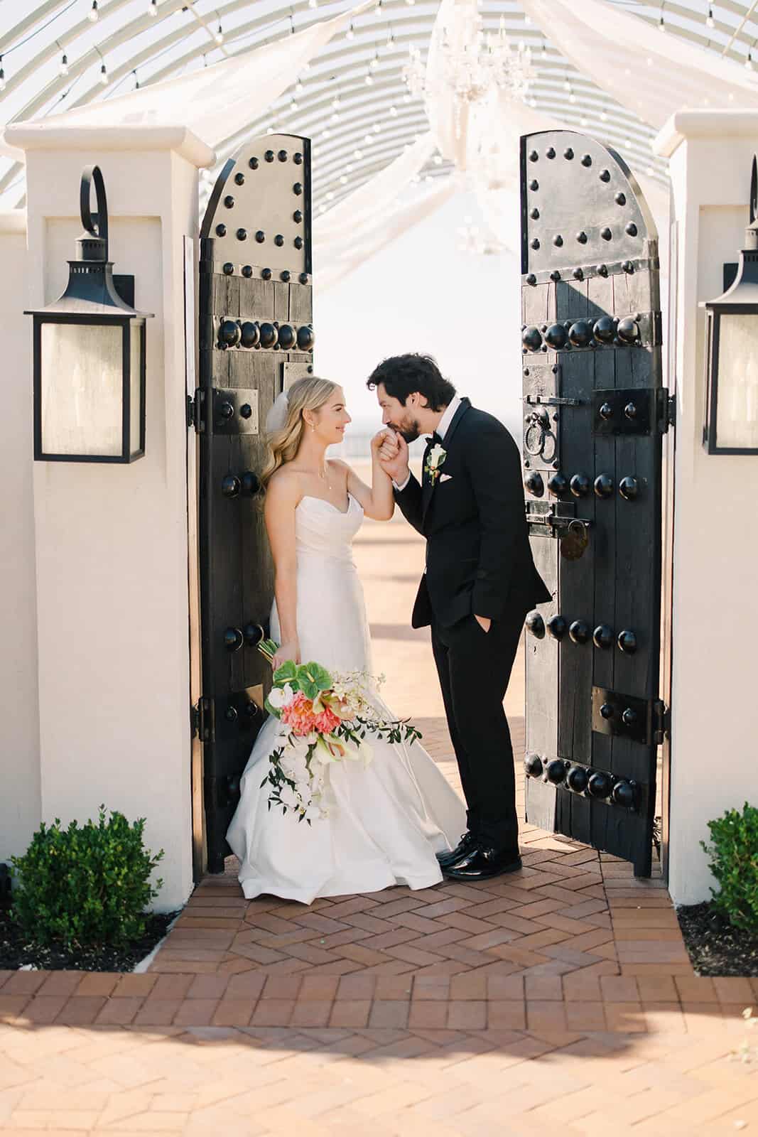 Romantic wedding moment between bride and groom at the venue entrance.