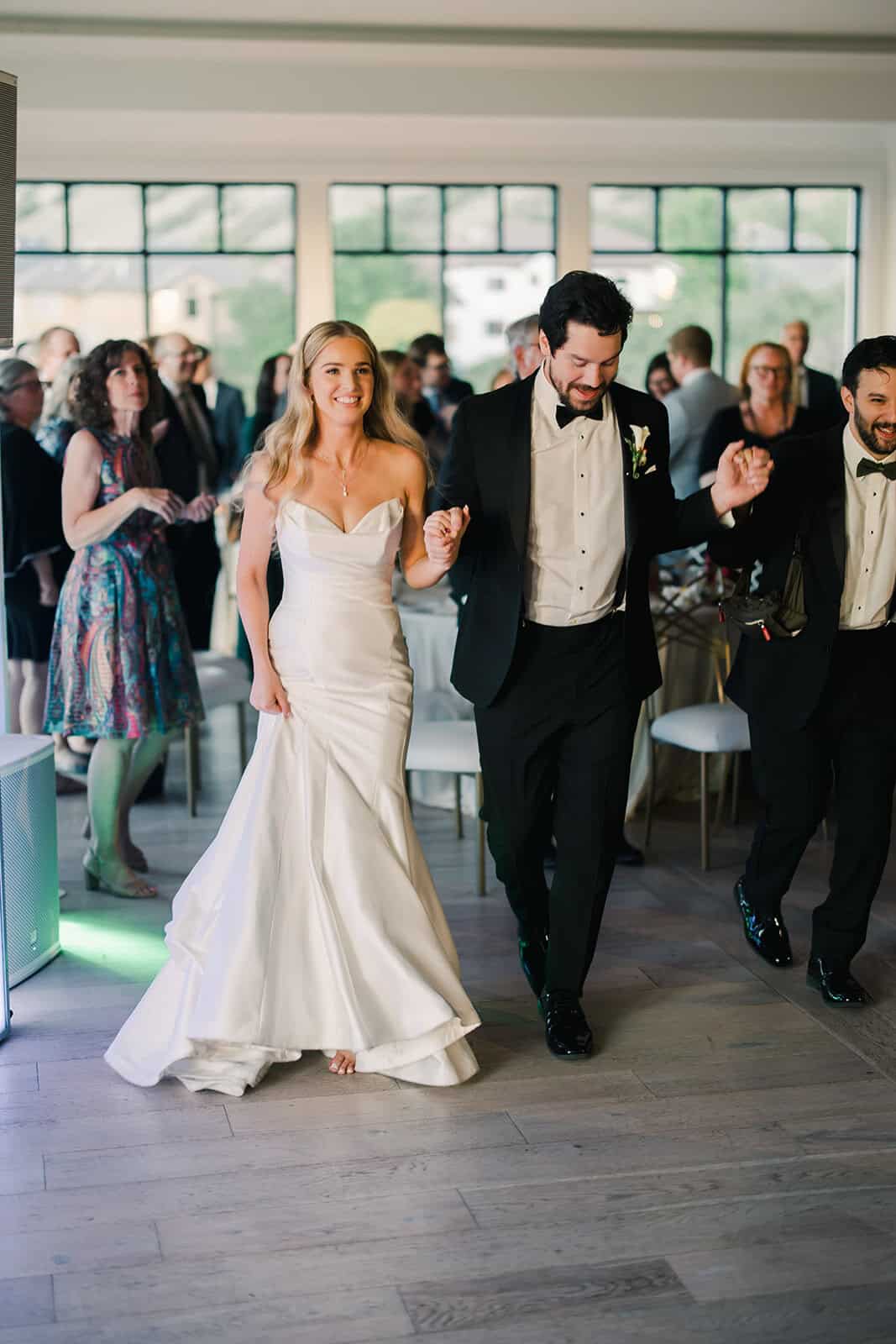 Bride and groom dancing at wedding reception in modern venue.