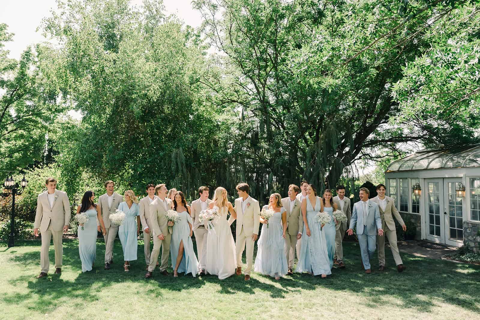 Wedding party outdoors at Branson Maxwell venue, with lush greenery and sunlight.