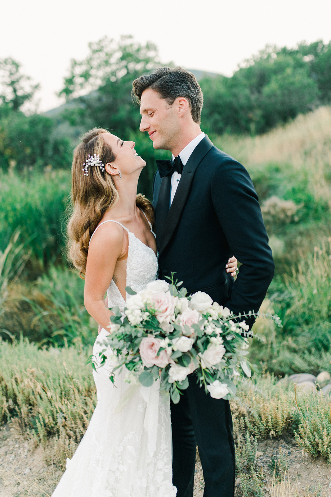 Bride and Groom Smile and Embrace During Blue Sky Ranch Wedding Photos