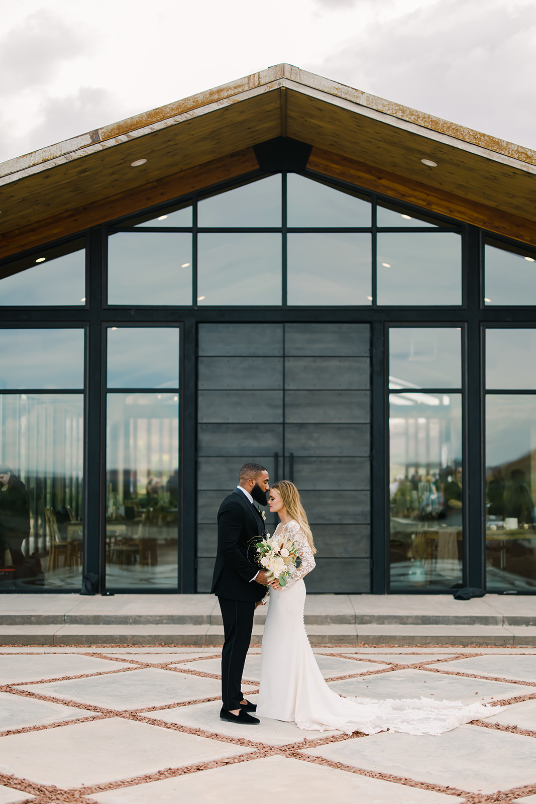 Bride and Groom Embrace in Front of Red Earth Venue Utah